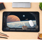Coffee beside a Spacecraft Window desk mat — product mockup 1